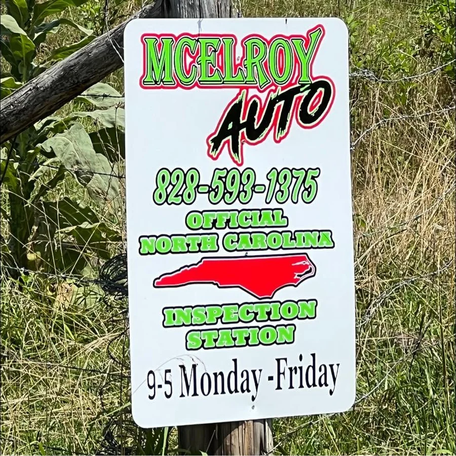McElroy Auto official North Carolina inspection station sign showing phone number and Monday through Friday, 9 to 5 hours