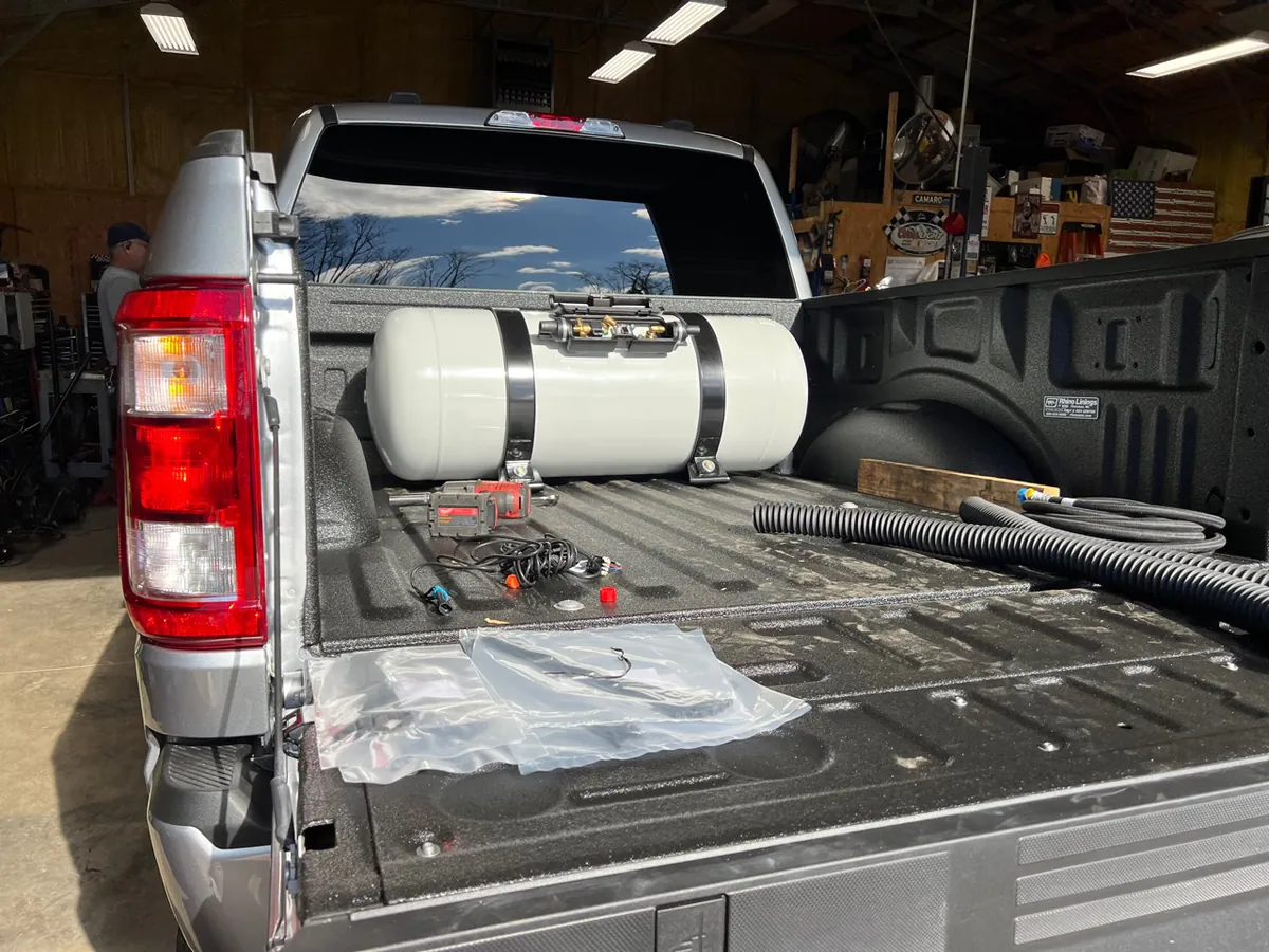 Propane fleet-conversion tank and hardware installed in a pickup bed at McElroy Auto Repair